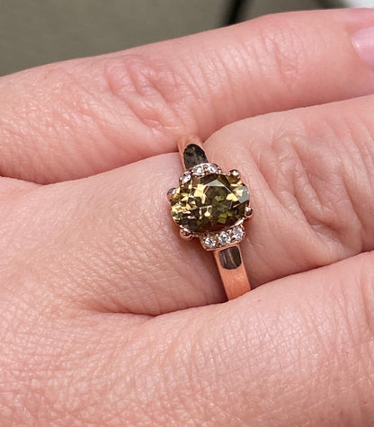 Oval greenish-gold zircon and diamond ring in rose gold.