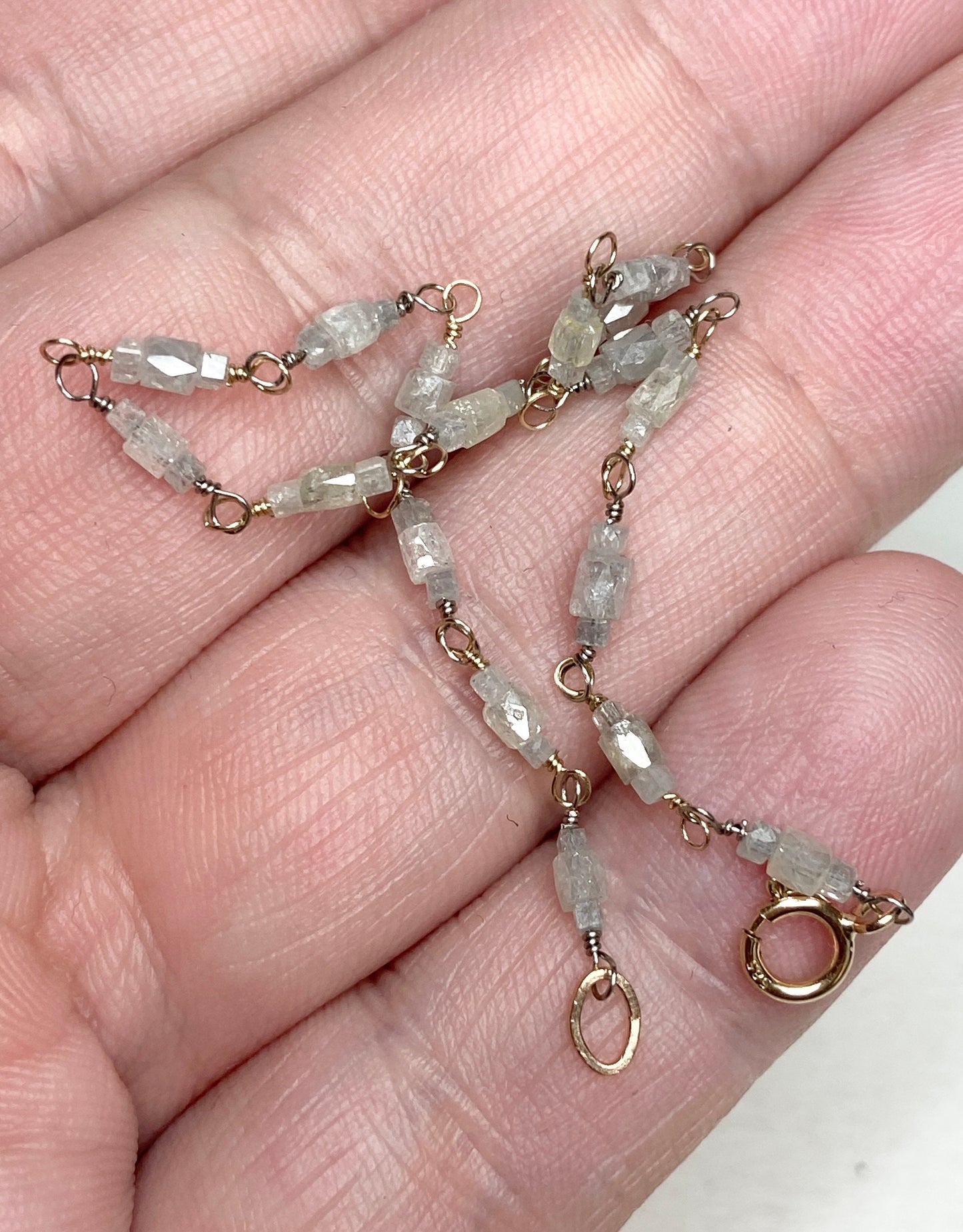 A bracelet with natural faceted diamond beads and a two-tone gold clasp.