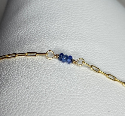 A 14k gold paperclip chain bracelet with untreated violet-blue Burmese sapphire beads.