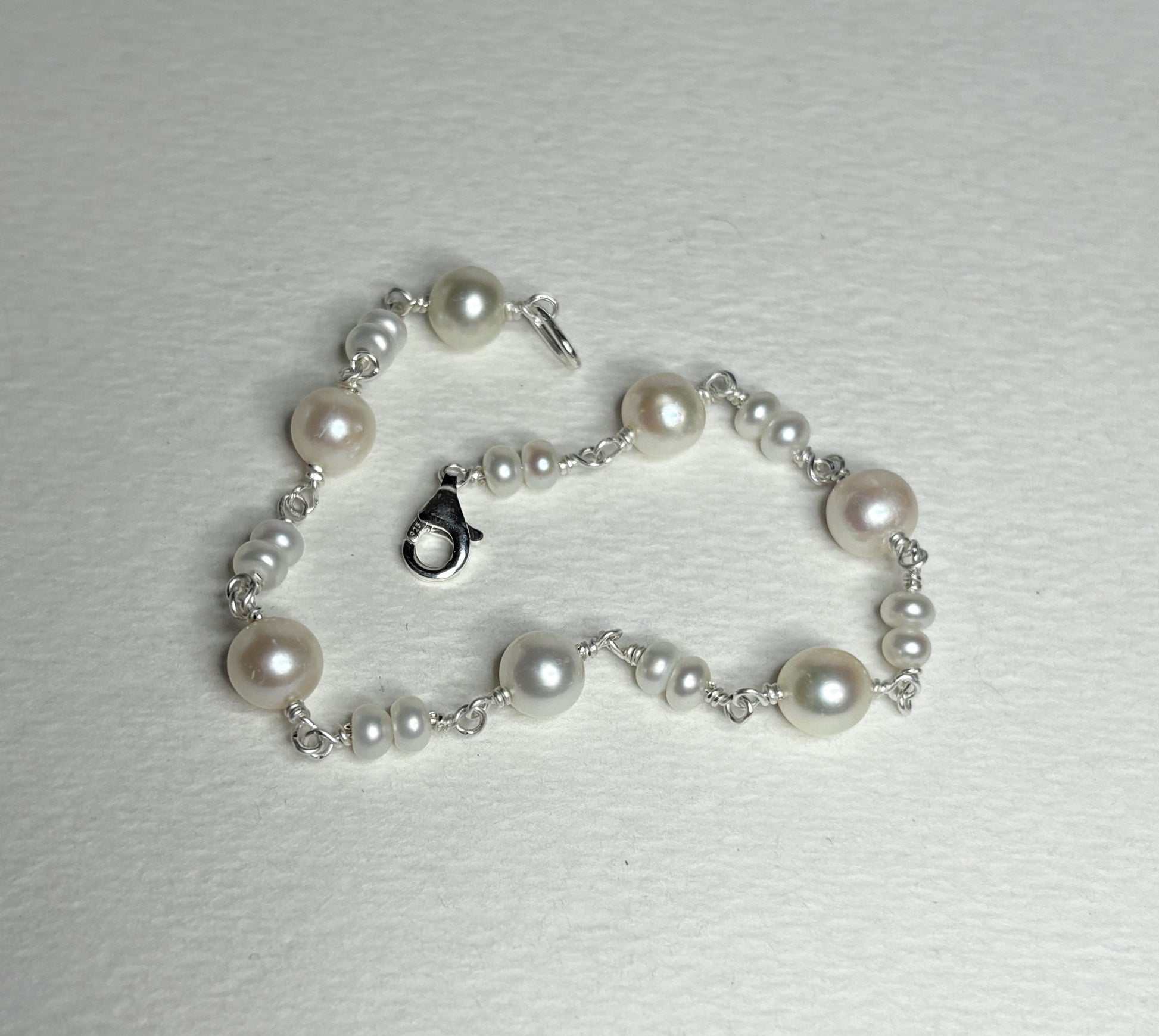 Sterling silver bracelet with cultured freshwater pearls.