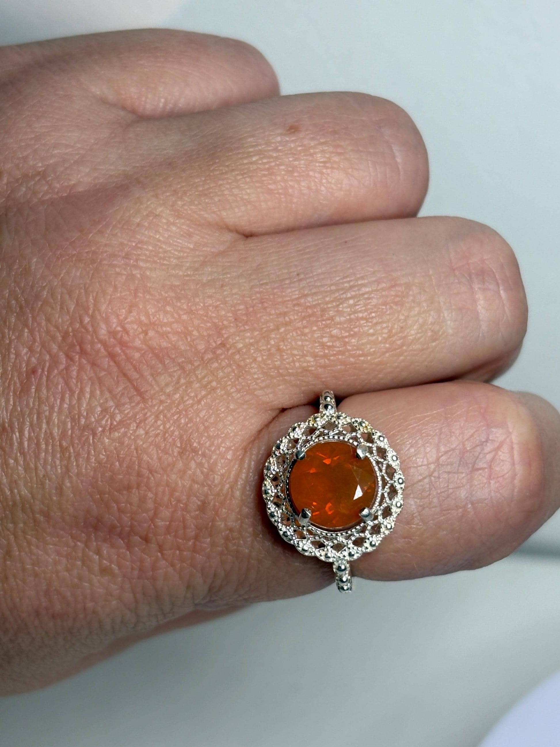 Sterling silver ring with a round Oregon fire opal and lacy filigree setting.