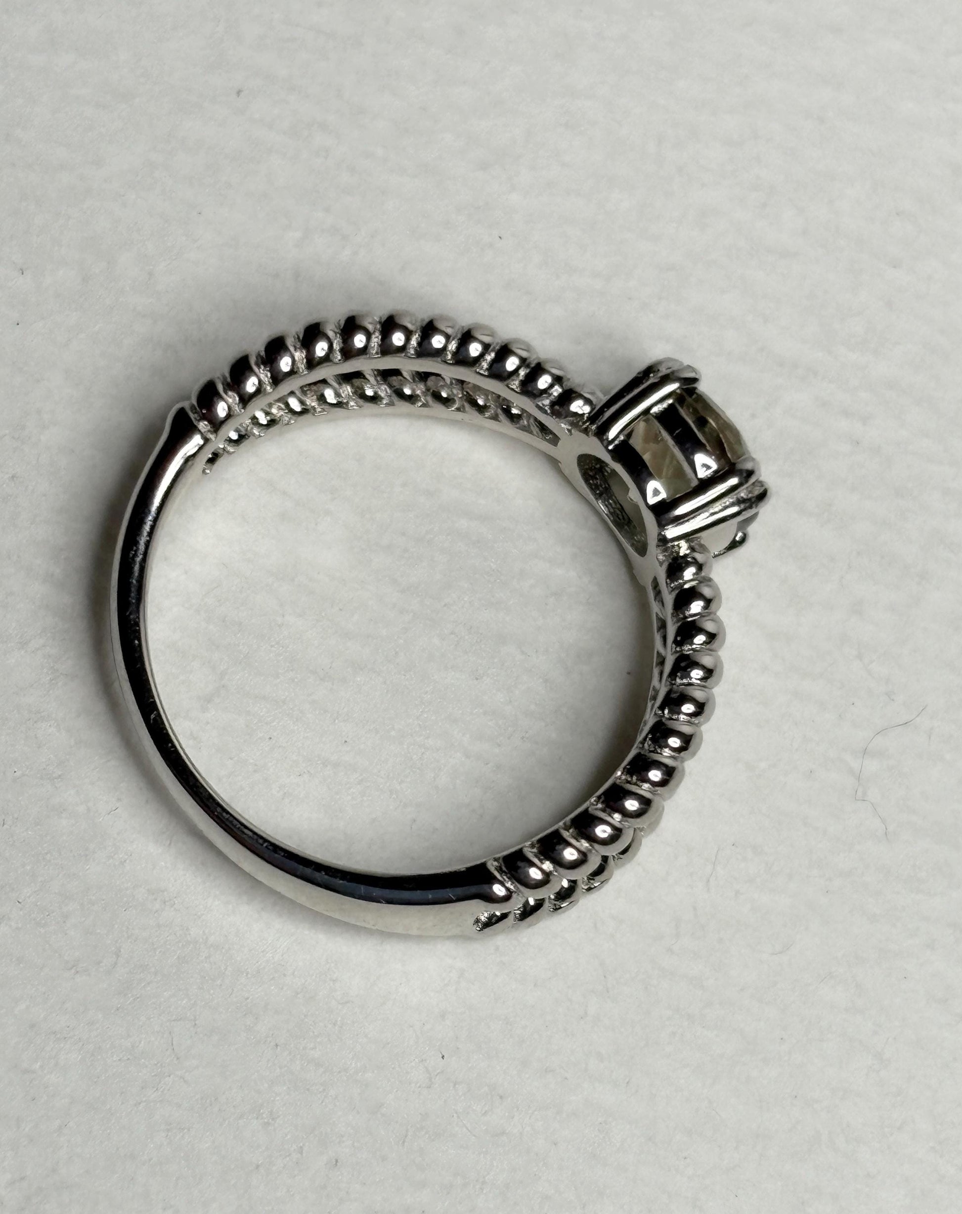 Sterling silver ring with a greenish Oregon sunstone and rope design.