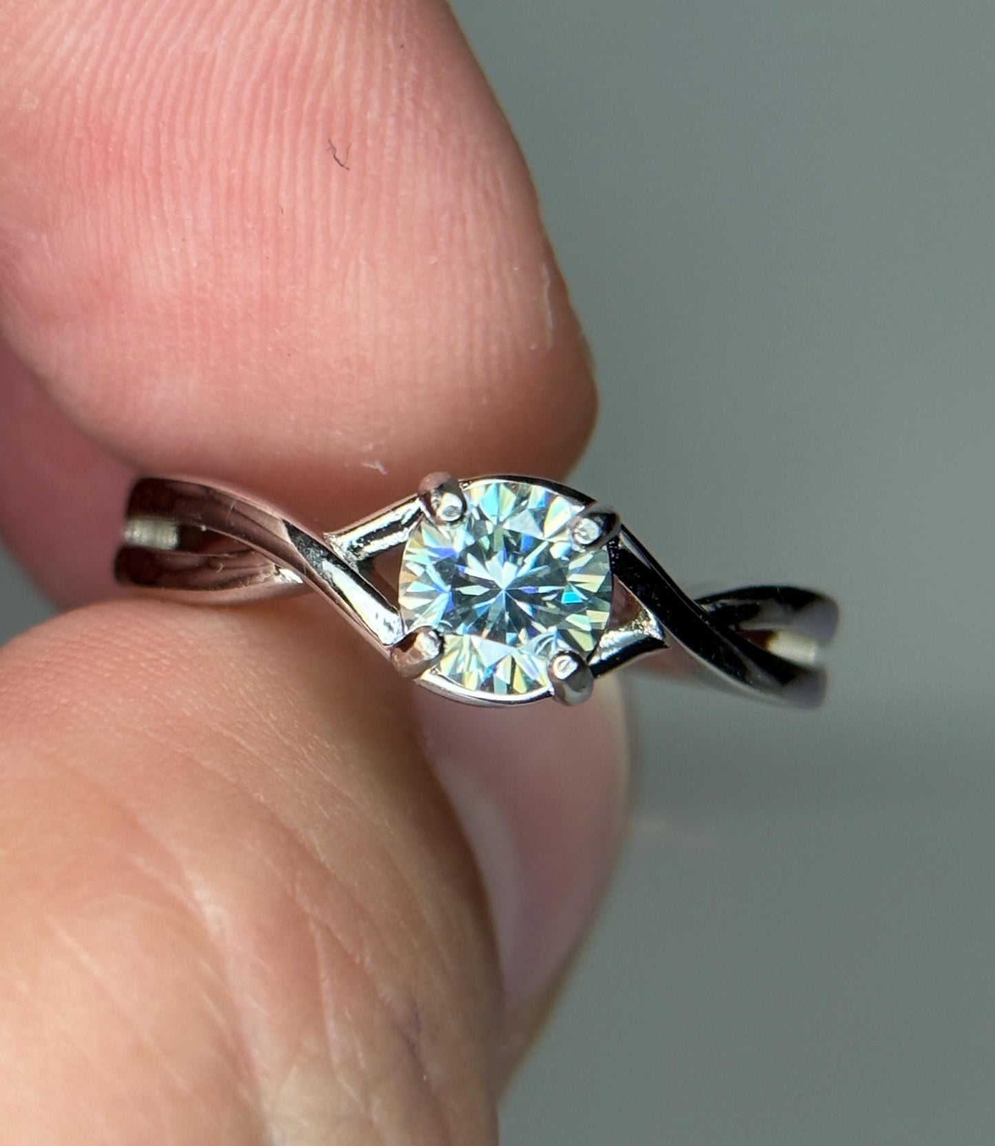 Sterling silver bypass ring with a light greenish-blue moissanite.