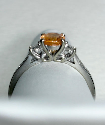 A 10k white gold ring with a Fanta orange spessartite garnet and diamonds.