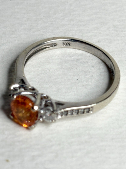 A 10k white gold ring with a Fanta orange spessartite garnet and accent diamonds.