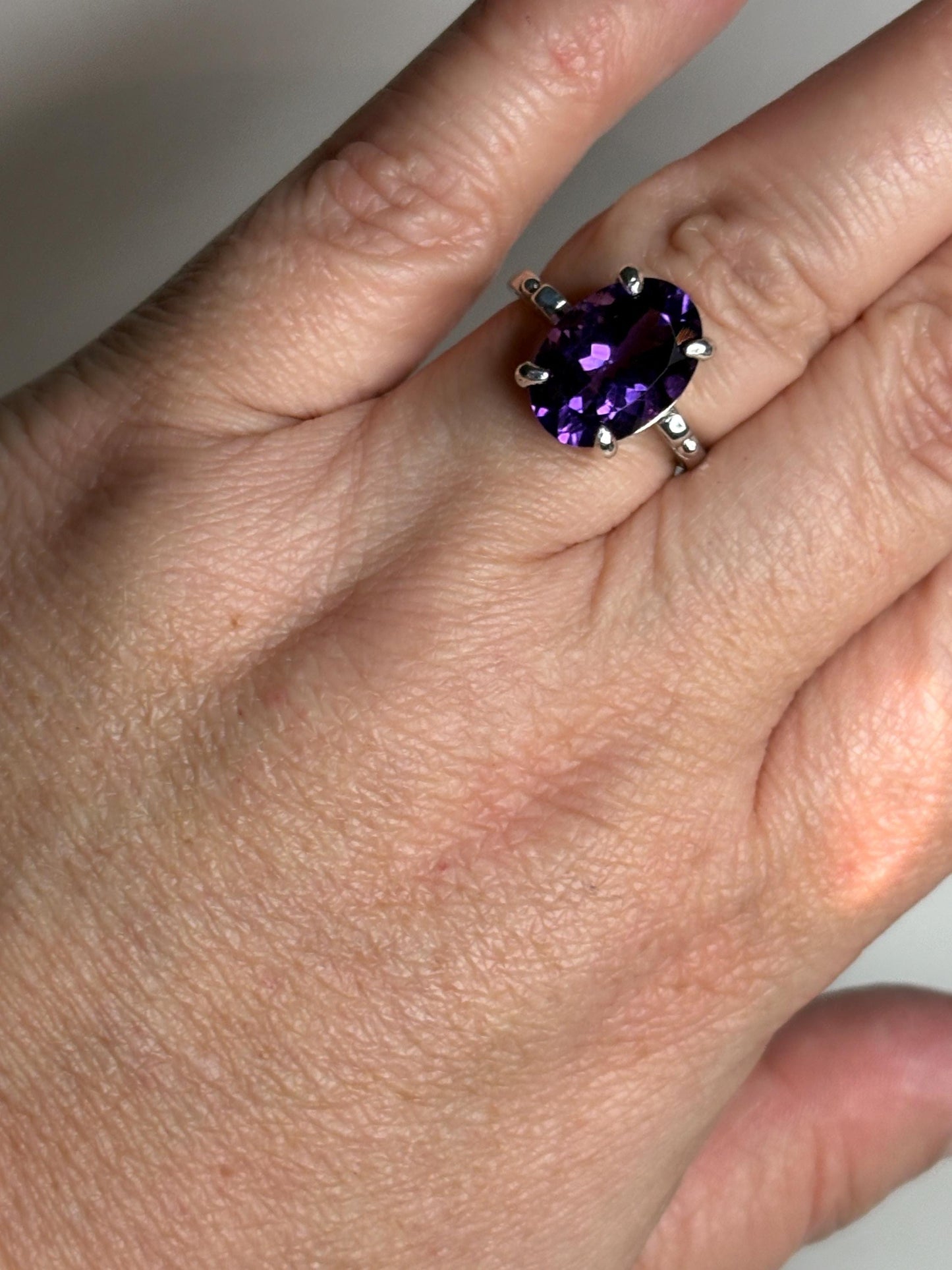 Sterling silver ring with a large oval amethyst gemstone.