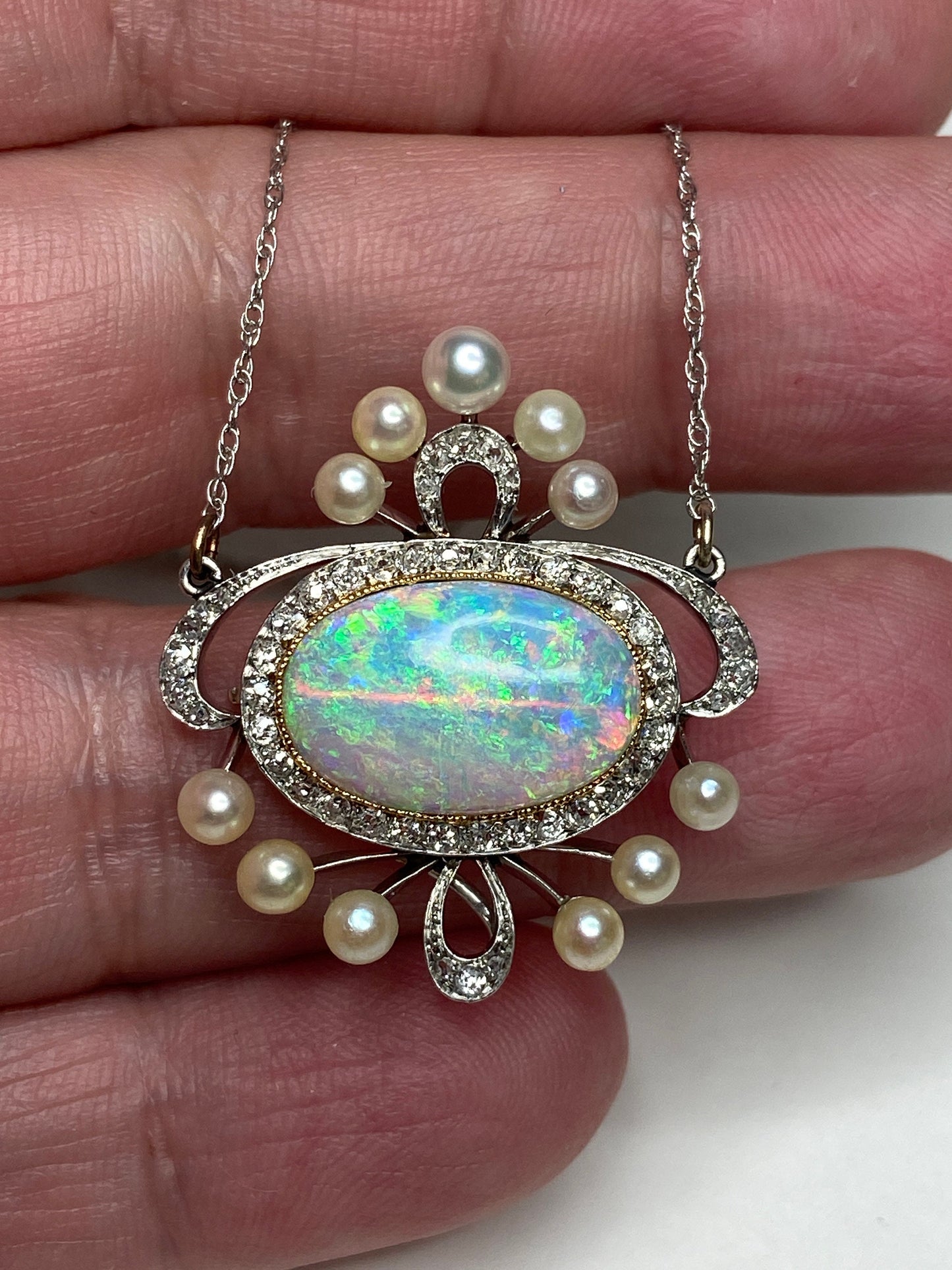 Edwardian platinum, 18k, and 14k gold pendant necklace with opal, pearls, and diamonds.