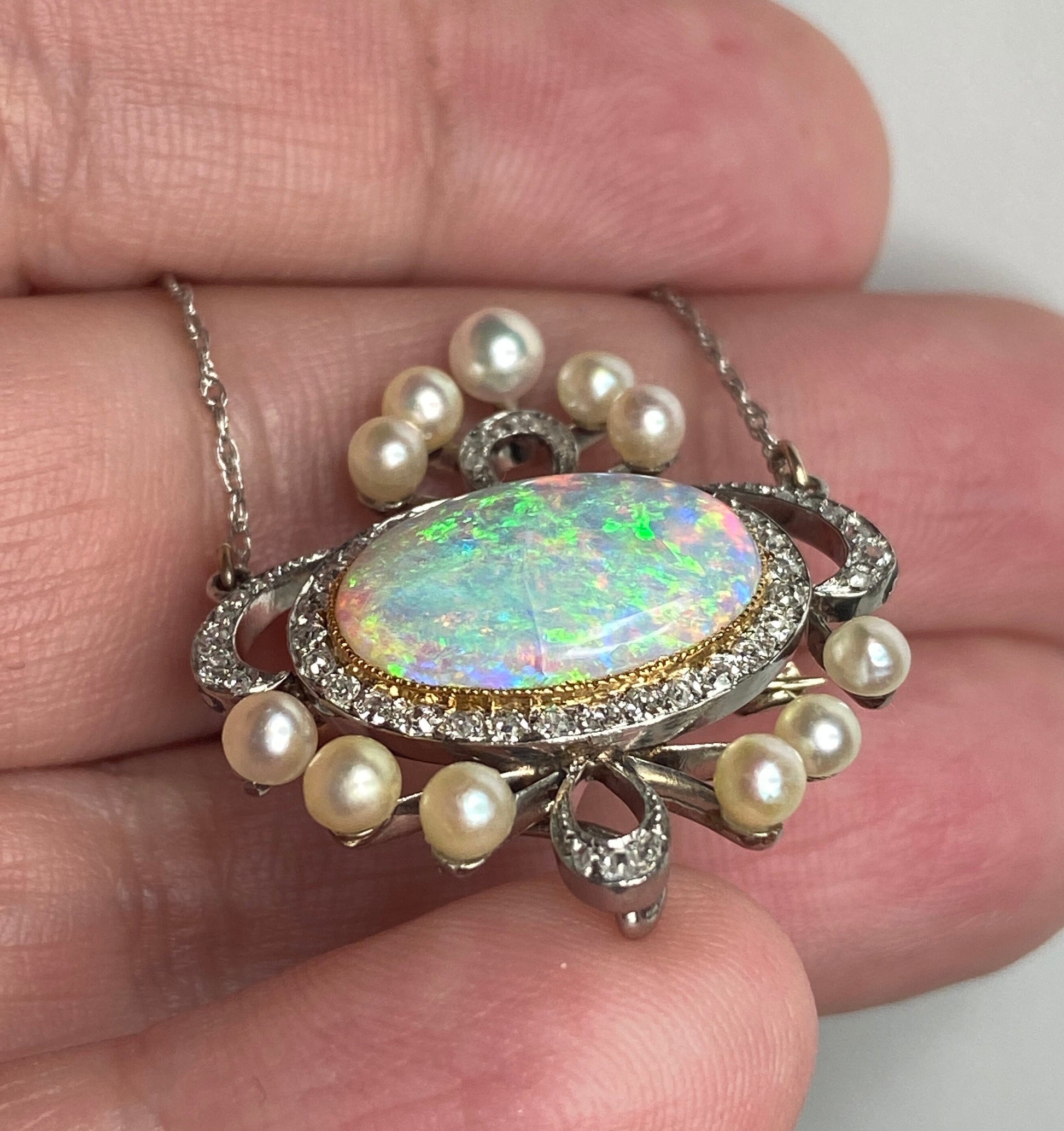 Edwardian platinum, 18k, and 14k gold pendant necklace with opal, pearls, and diamonds.