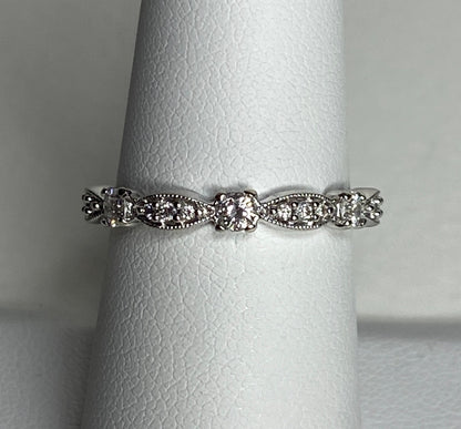 A 10k white gold band ring with diamonds and milgrain detailing.