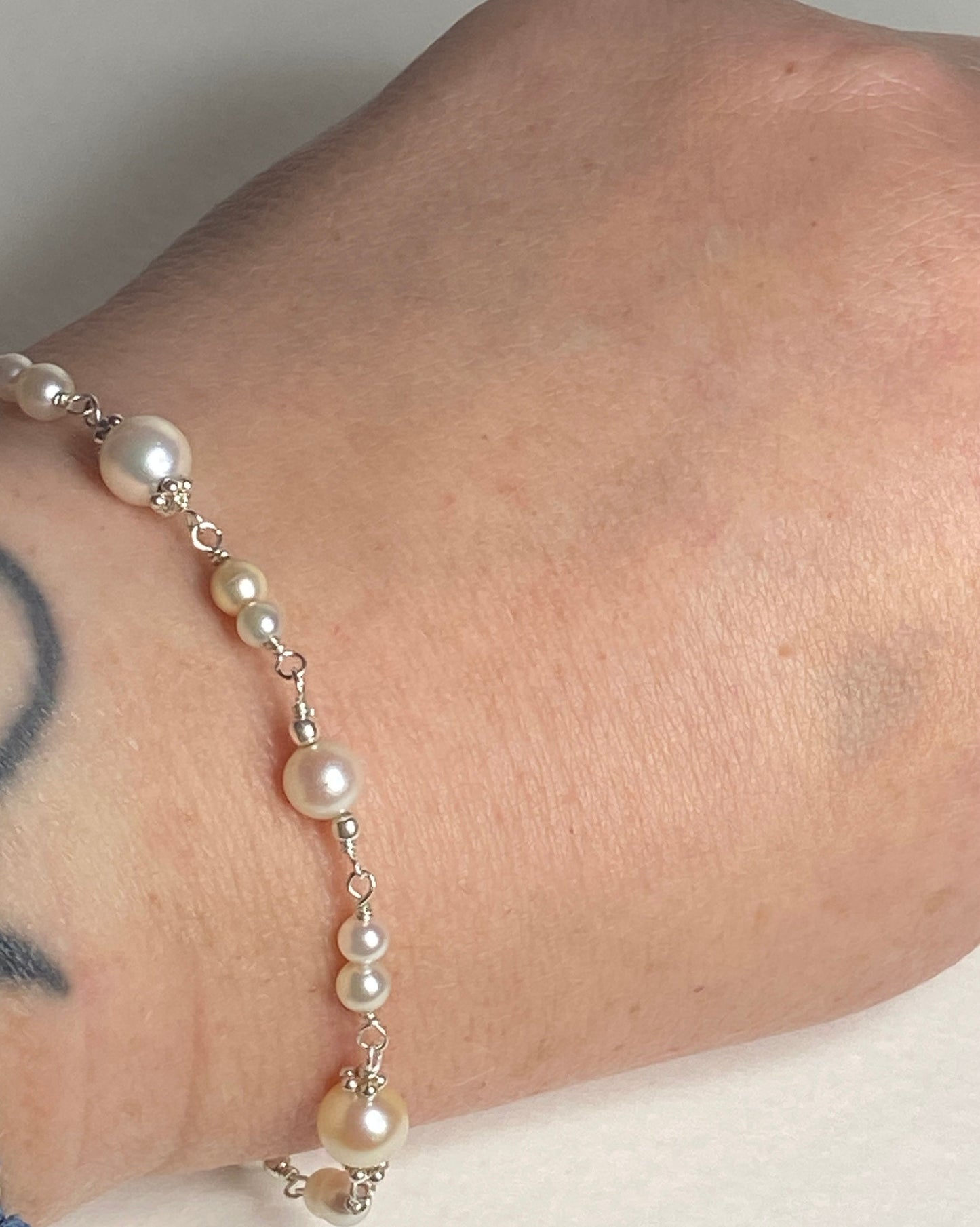 Sterling silver bracelet with multi-colored Akoya pearls of varying sizes.