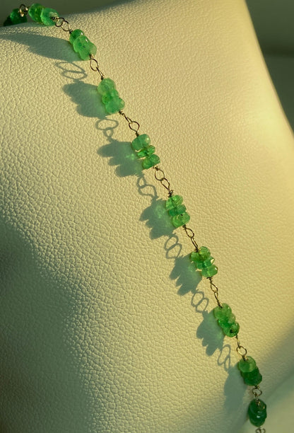 A delicate bracelet featuring raw emerald beads strung on gold wire.