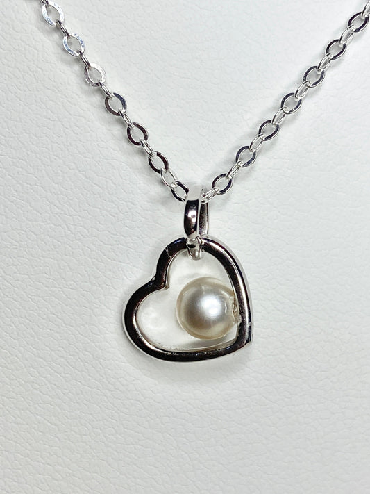 Sterling silver necklace with a heart pendant holding a cultured akoya pearl.