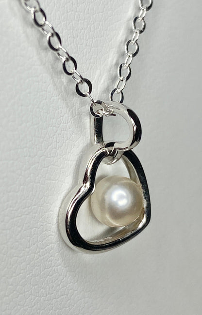Sterling silver necklace with a double heart pendant holding a 5mm cultured akoya pearl.