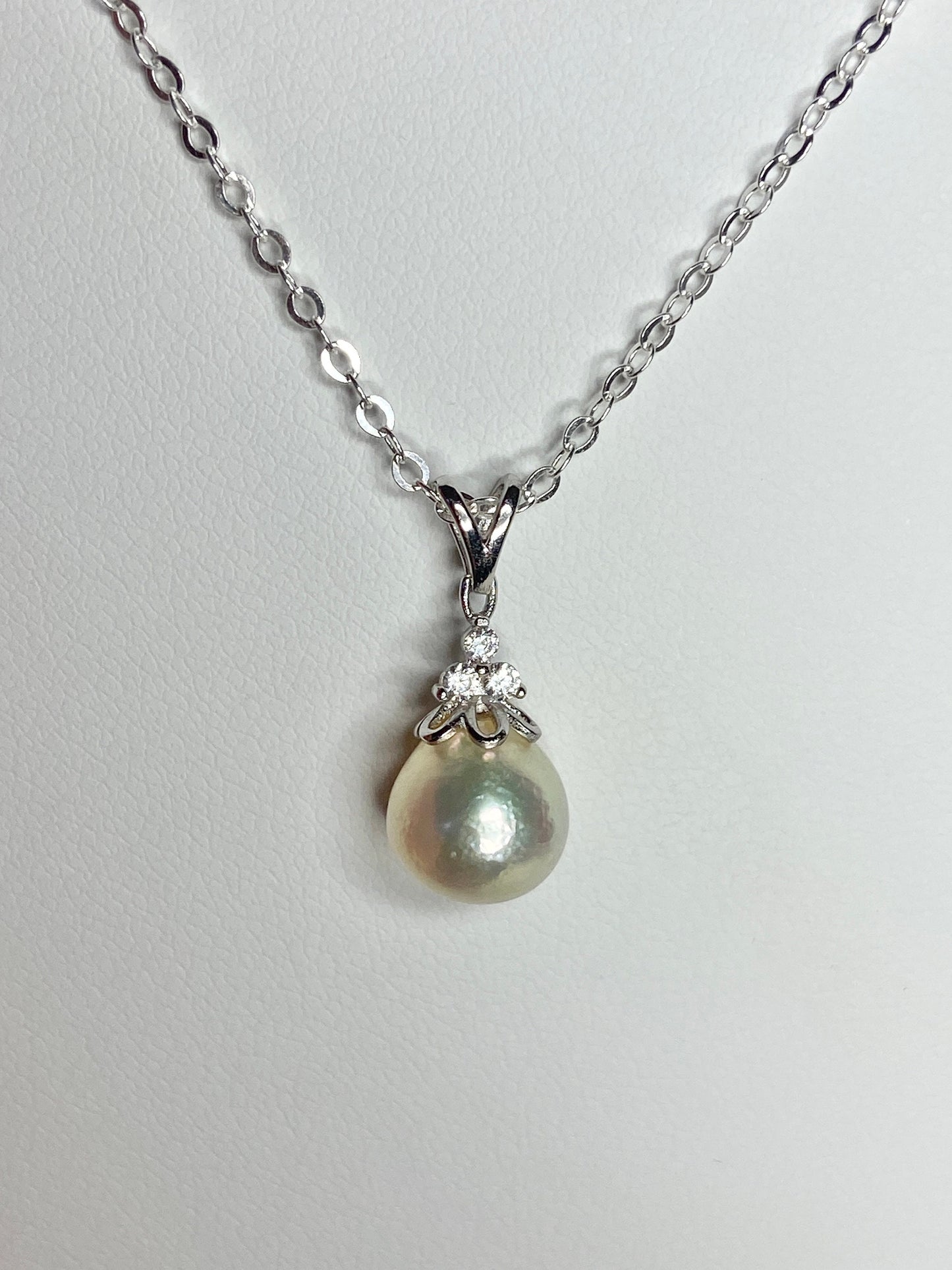 Sterling silver necklace with an out-of-round Akoya pearl pendant and crystal accents.