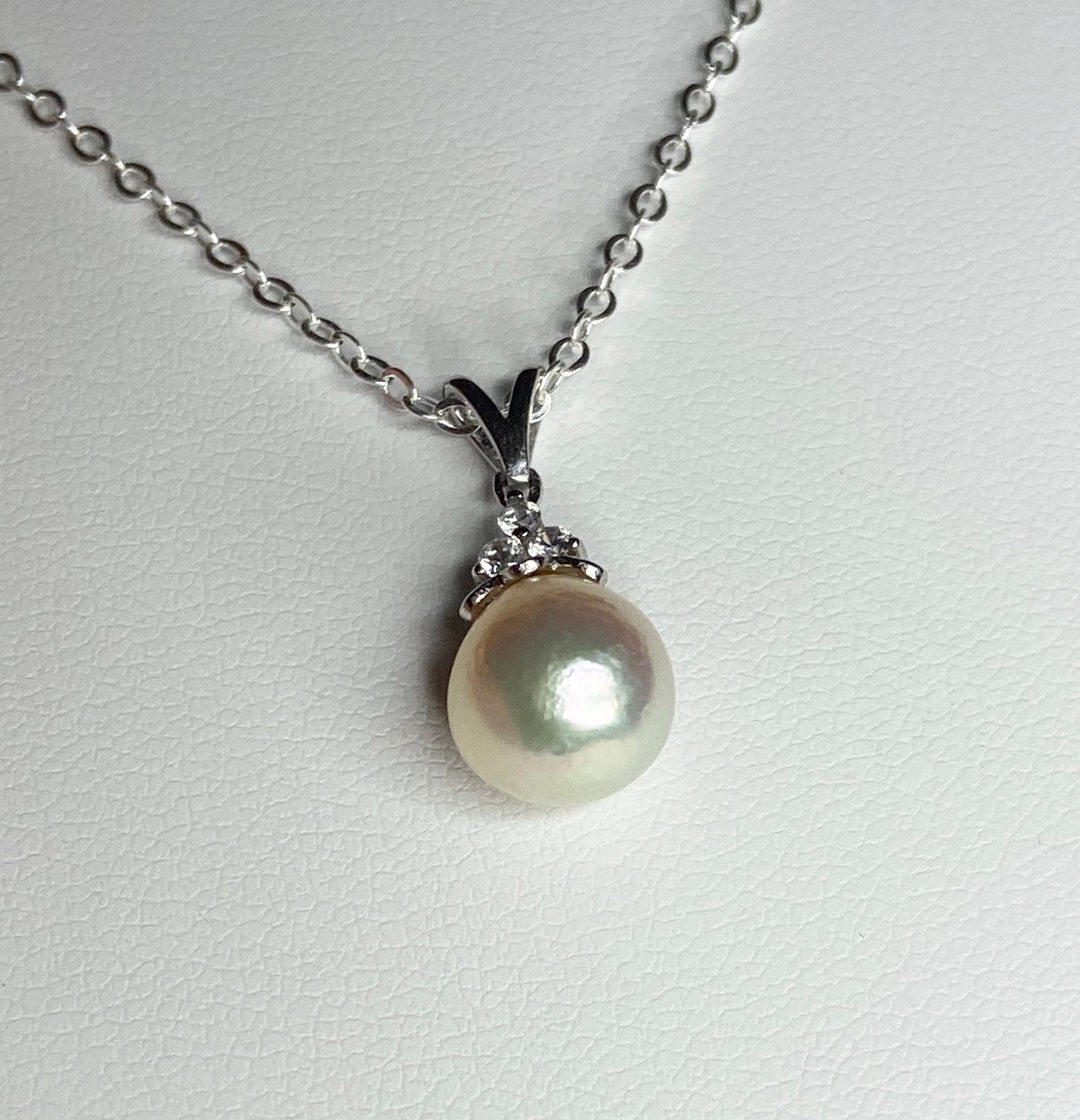 Sterling silver pendant necklace with an 8.5x8mm out-of-round Akoya pearl and three crystals.