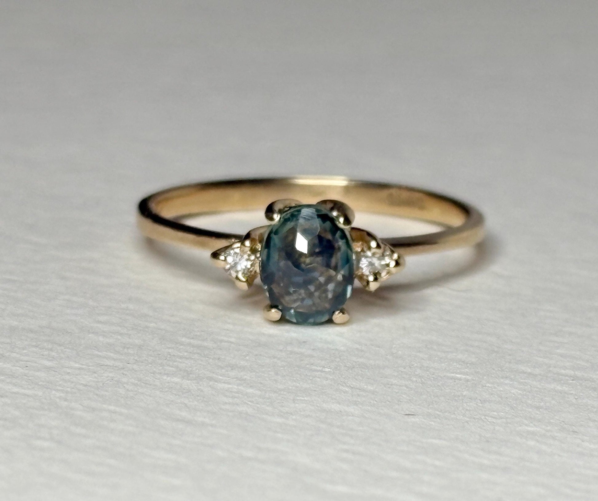 Oval Montana sapphire and diamond ring in 14k yellow gold.