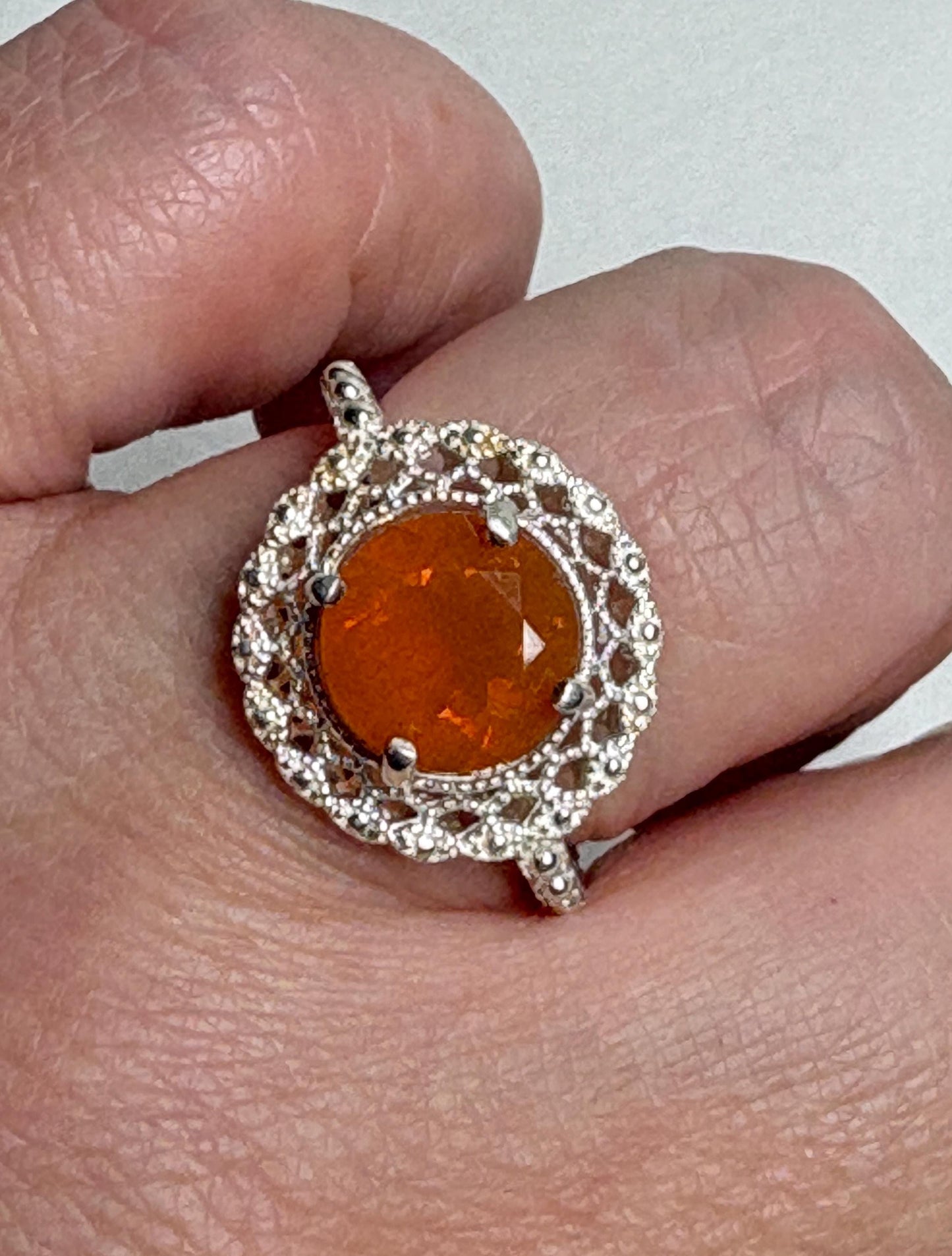 Sterling silver ring with a round Oregon fire opal and lacy filigree setting.