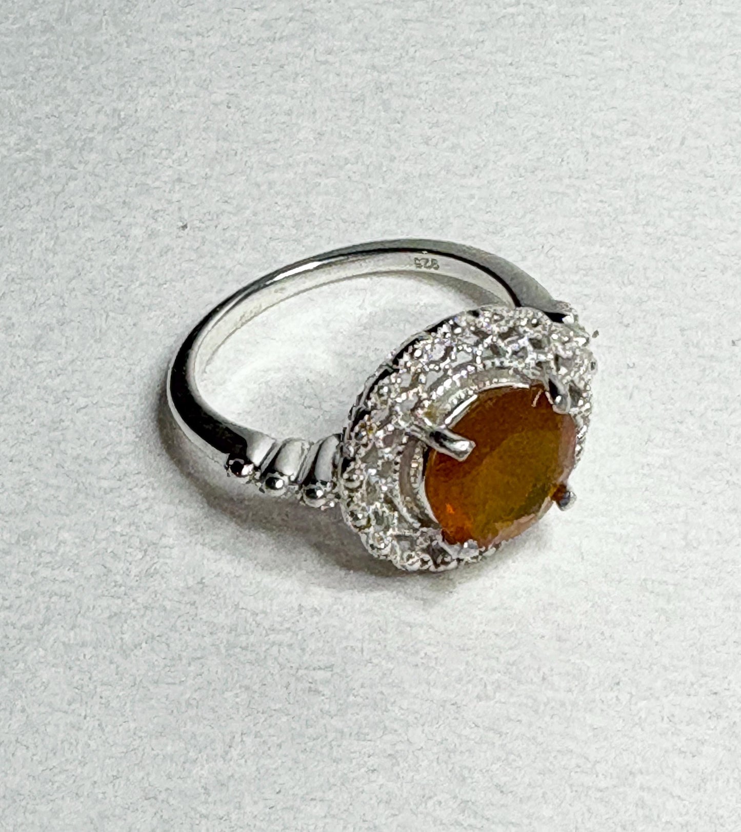 Sterling silver ring with a round Oregon fire opal and lacy filigree setting.