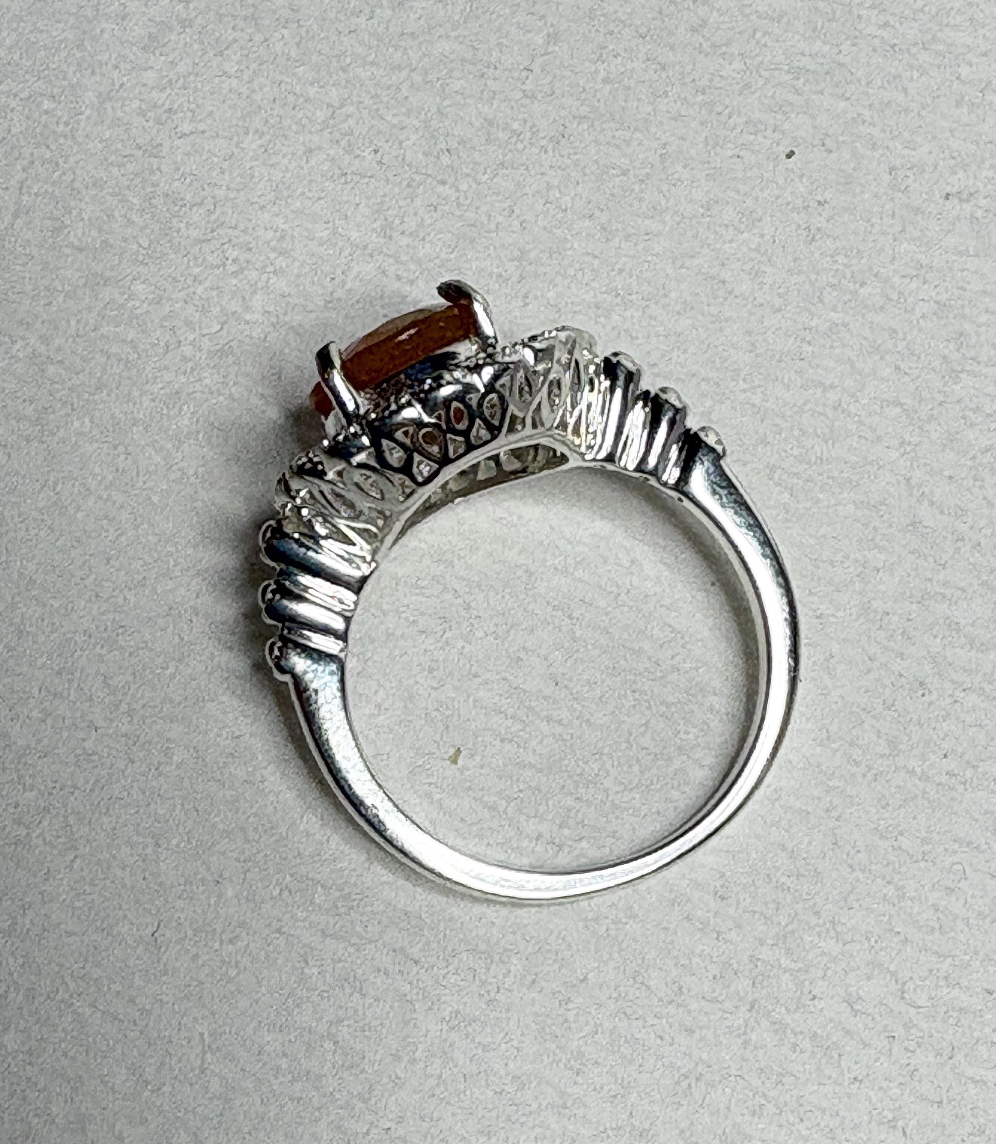 Sterling silver ring with a round Oregon fire opal and lacy filigree setting.