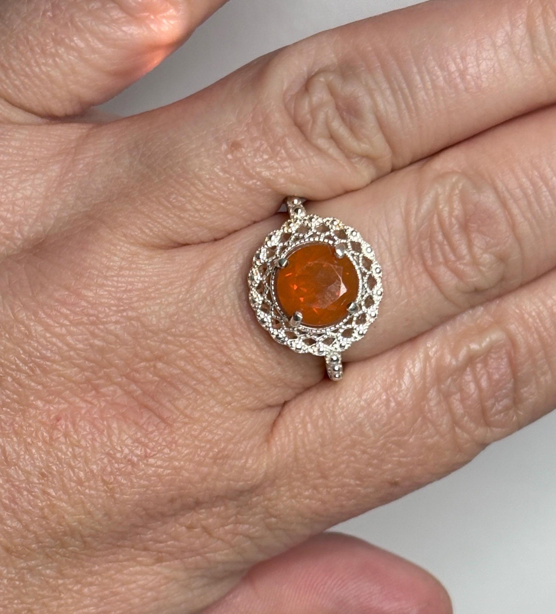 Sterling silver ring with a round Oregon fire opal and lacy filigree setting.