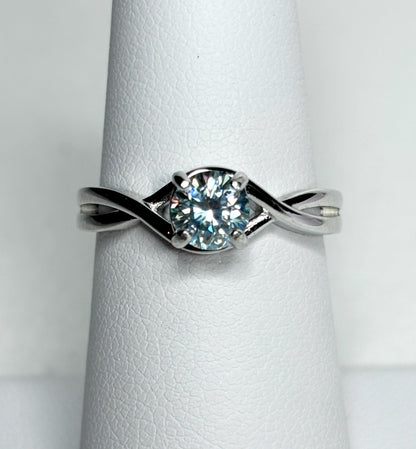 Sterling silver bypass ring with a light greenish-blue moissanite solitaire.