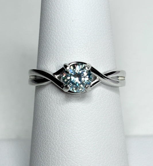 Sterling silver bypass ring with a light greenish-blue moissanite solitaire.
