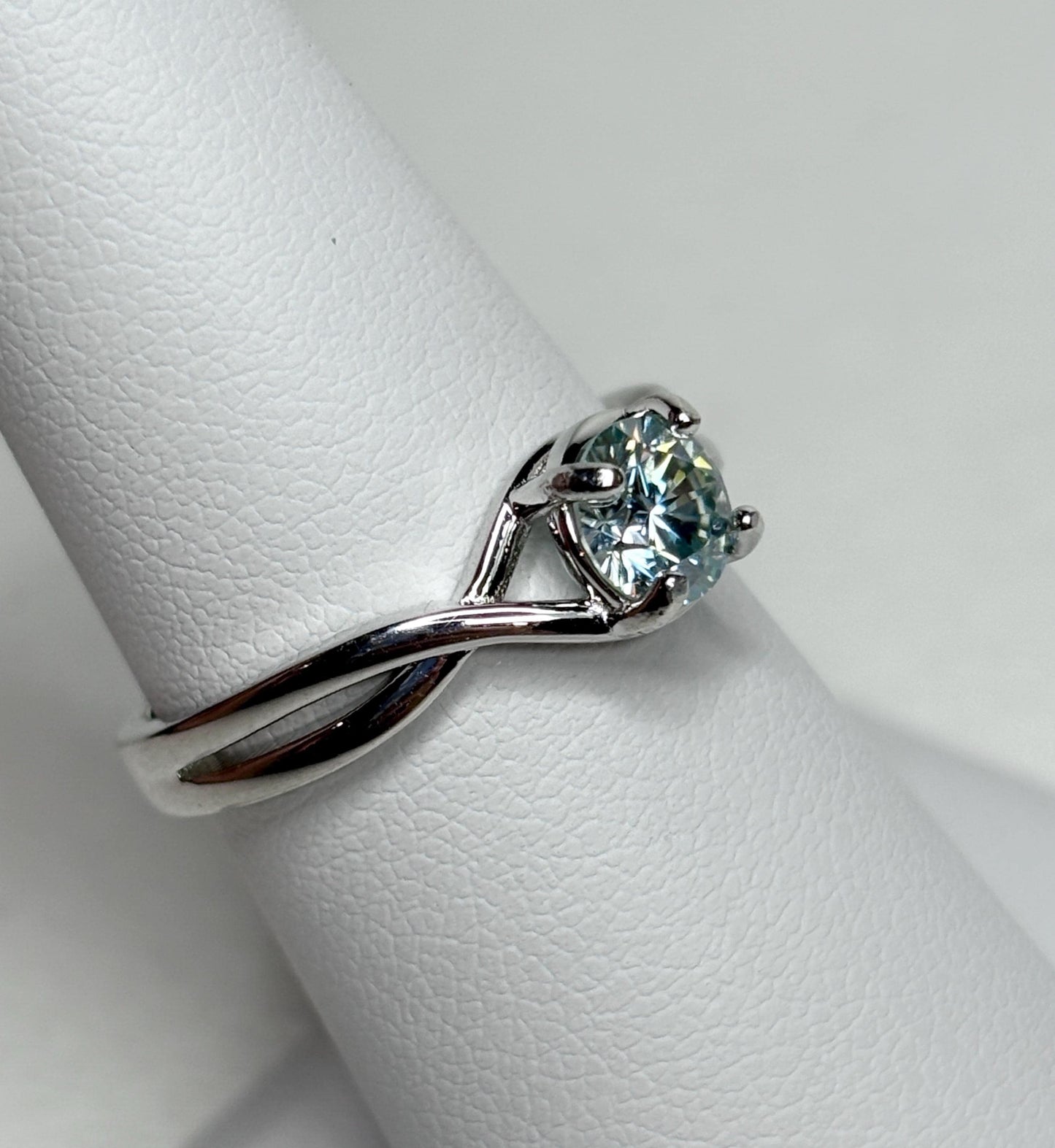 Sterling silver bypass ring with a light greenish-blue moissanite.