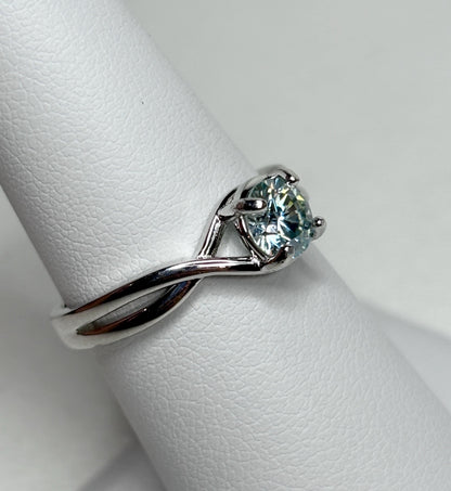 Sterling silver bypass ring with a light greenish-blue moissanite.