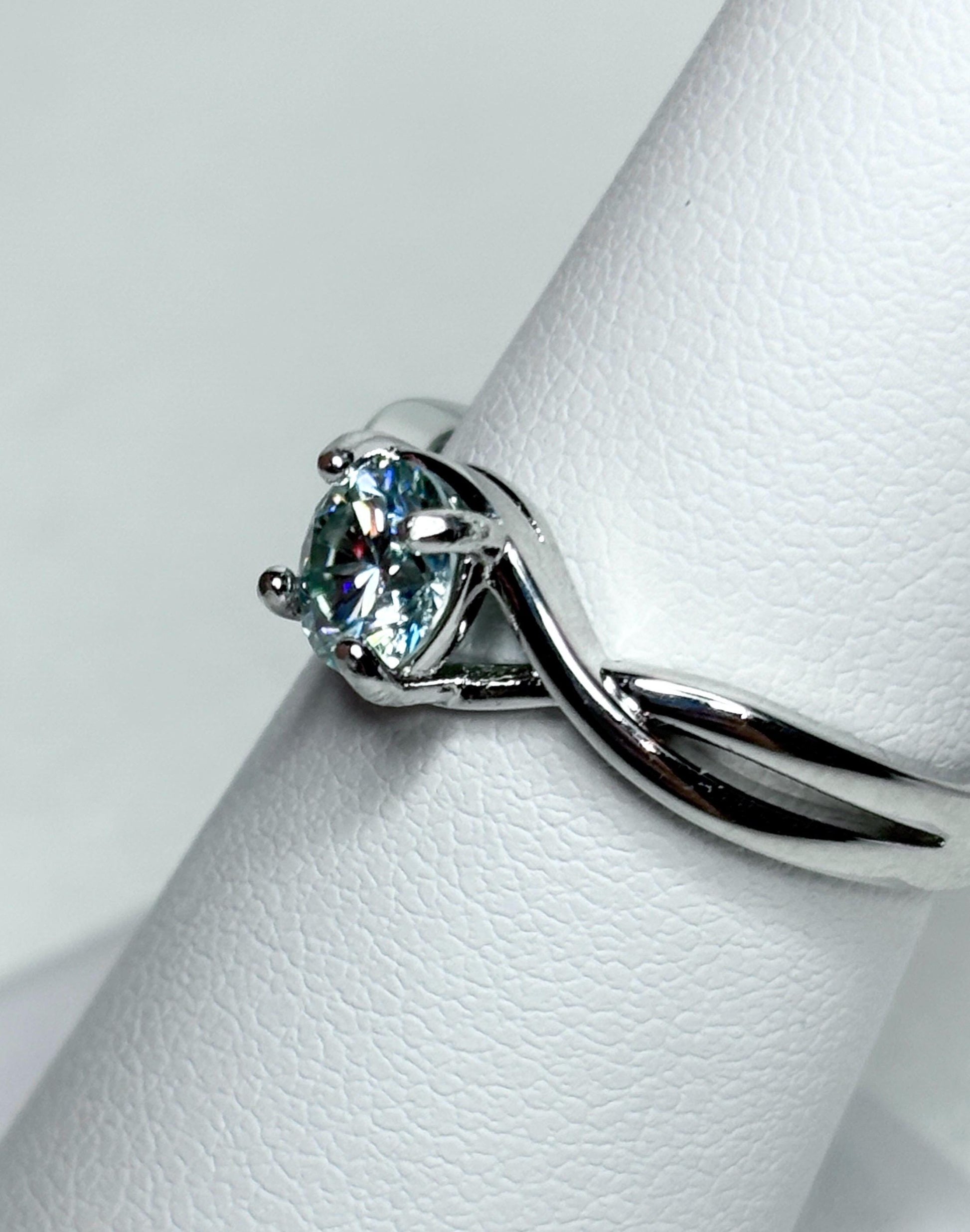 Sterling silver bypass ring with a light greenish-blue moissanite.