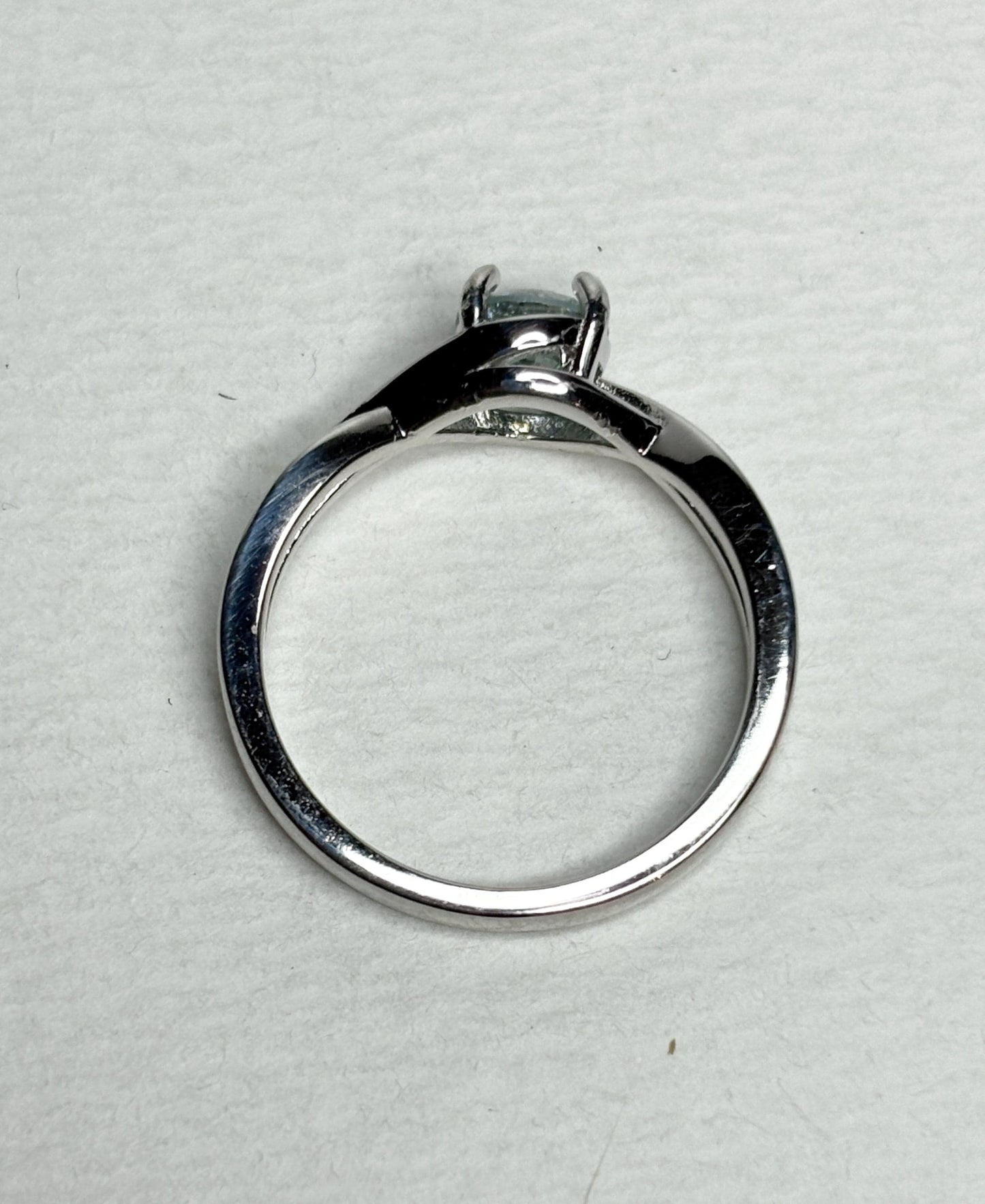 Sterling silver bypass ring with a light greenish-blue moissanite.