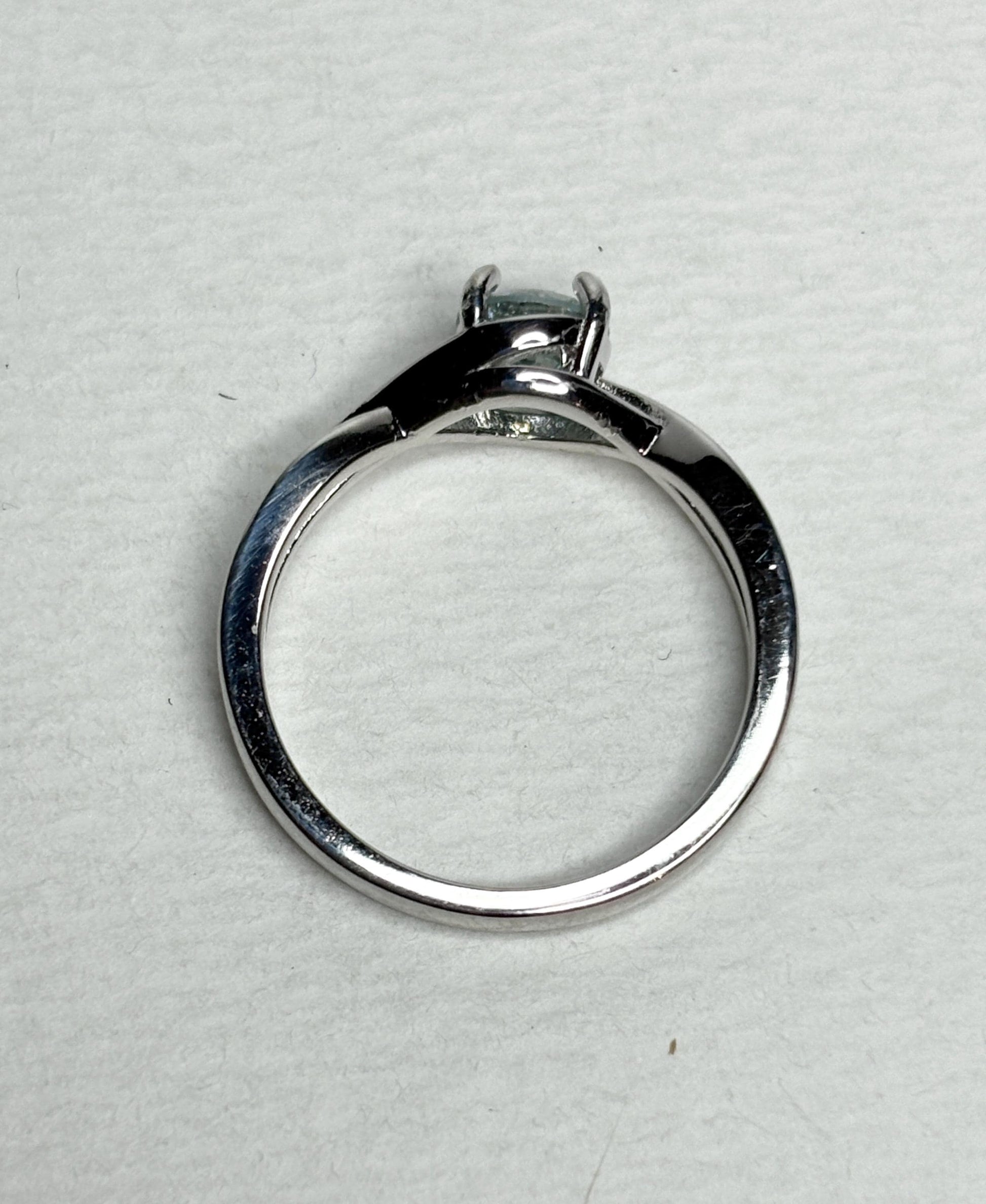 Sterling silver bypass ring with a light greenish-blue moissanite.