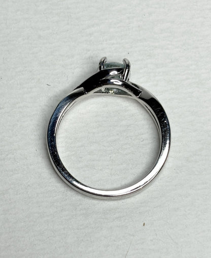 Sterling silver bypass ring with a light greenish-blue moissanite.