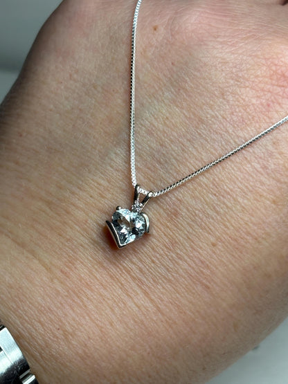 A 10k white gold heart pendant with an aquamarine and diamond on a sterling silver chain.