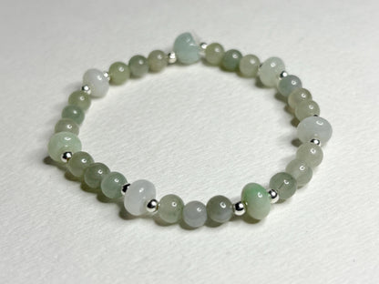 A natural Type A icy Burmese jadeite jade stretch bracelet with sterling silver accents.