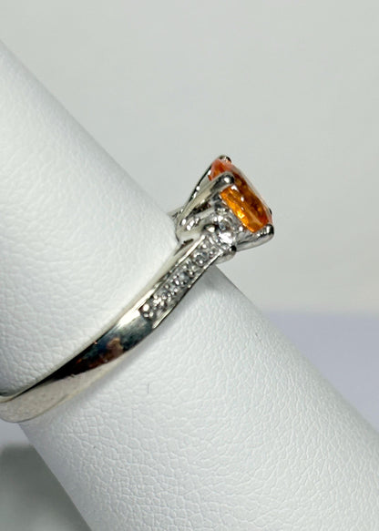 A 10k white gold ring with a Fanta orange spessartite garnet and diamonds.