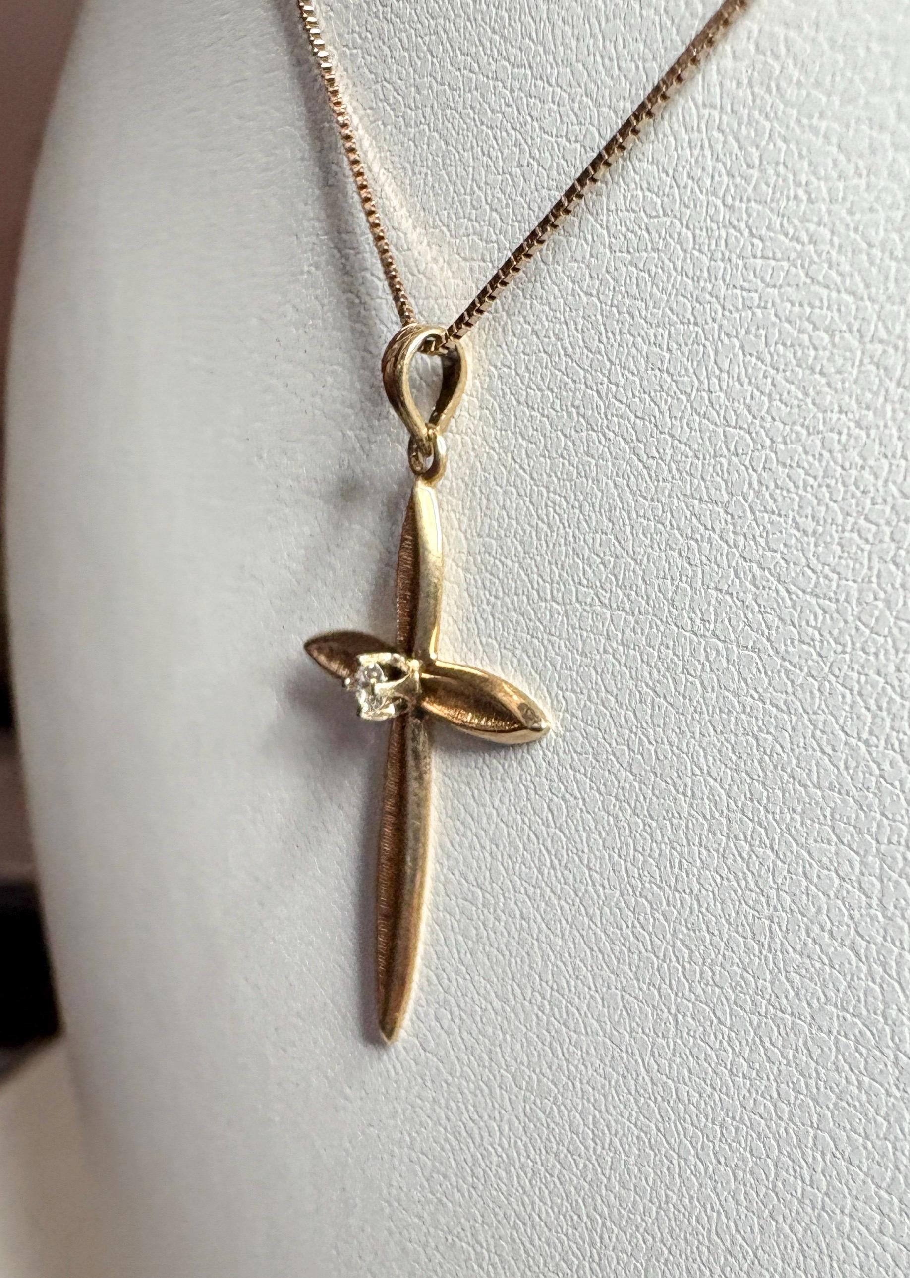 A solid 14k gold cross pendant with a diamond on a 10k gold box chain.