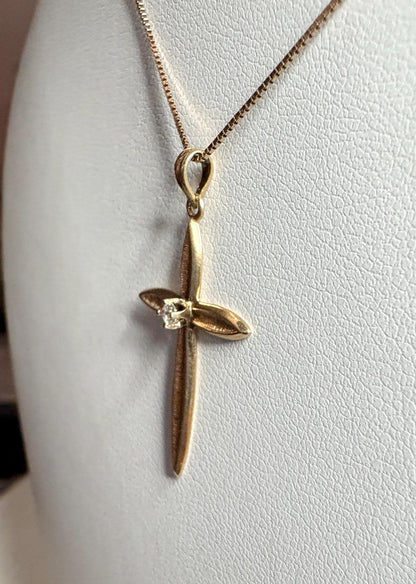A solid 14k gold cross pendant with a diamond on a 10k gold box chain.
