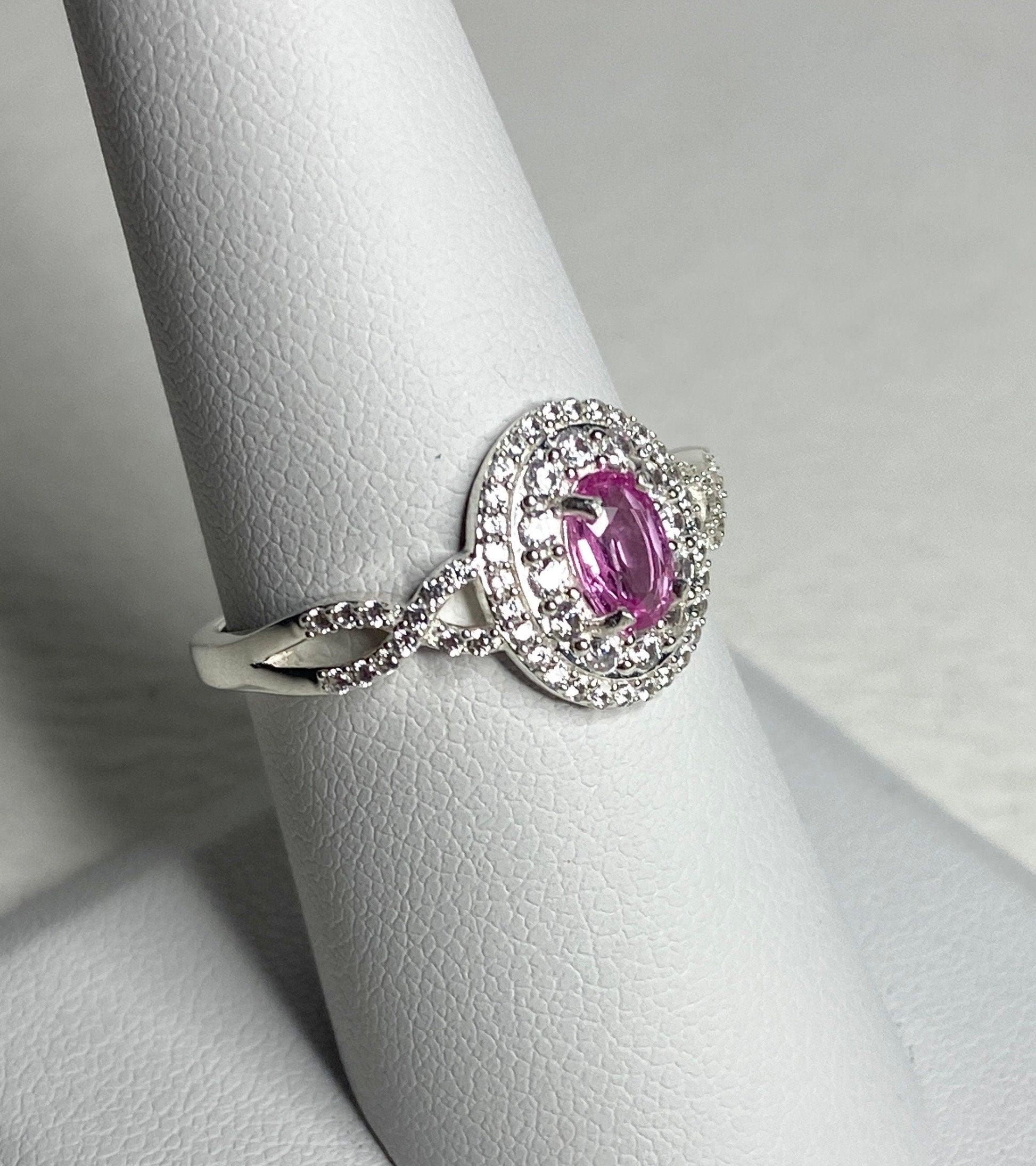 Sterling silver ring with oval pink sapphire and double halo of zircon.