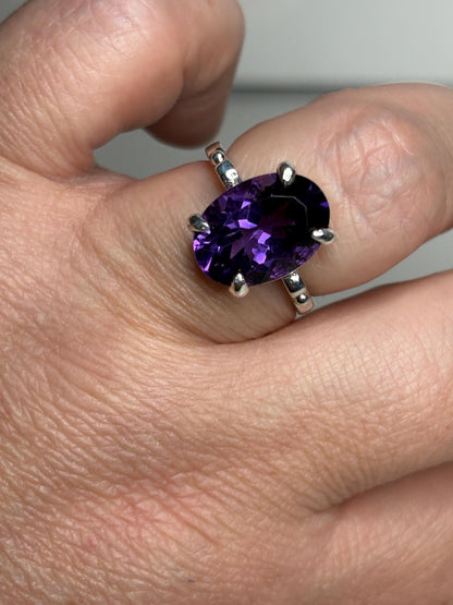 Sterling silver ring with a large oval amethyst gemstone.