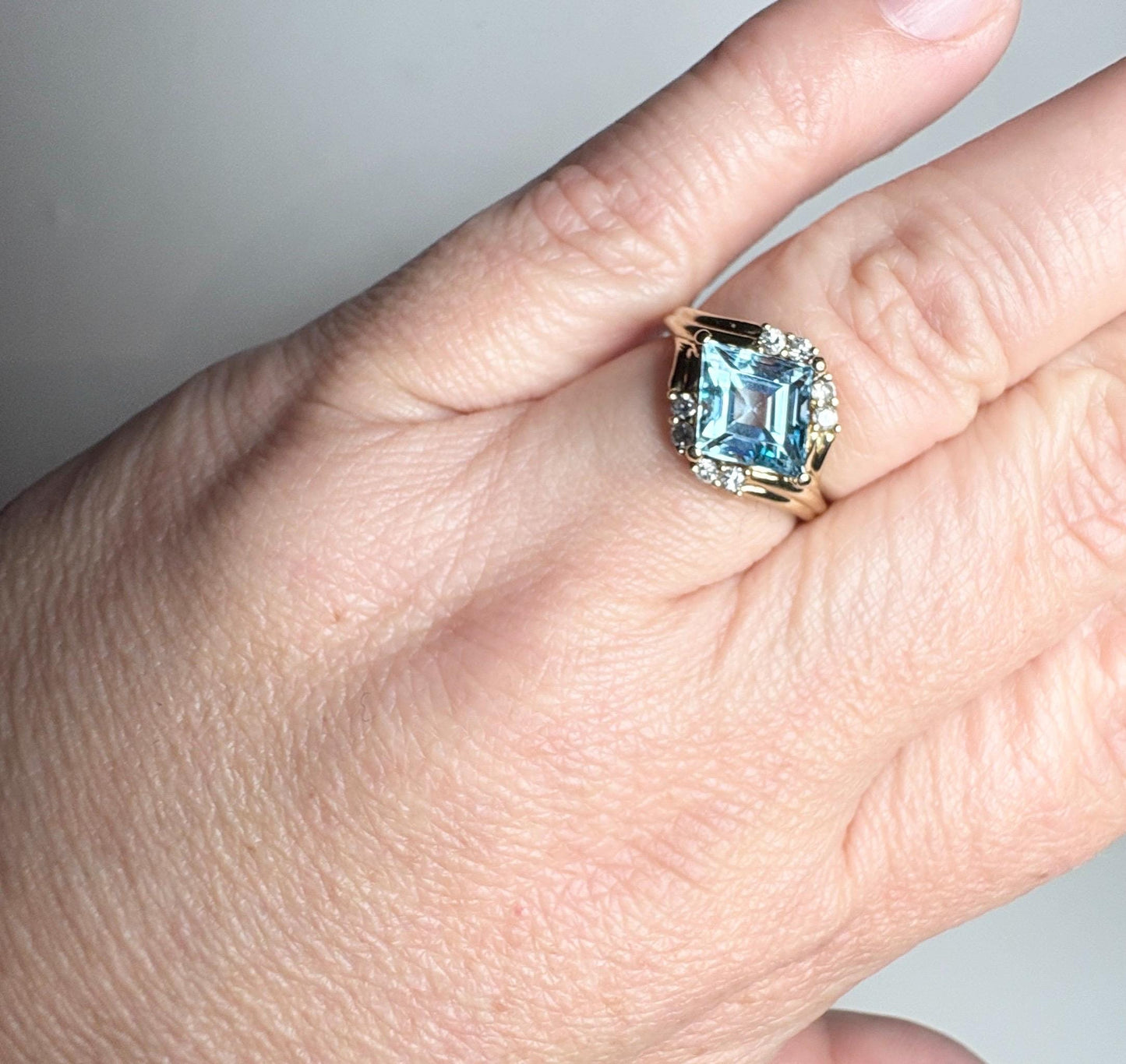 14k gold ring with a blue topaz and diamond accent.