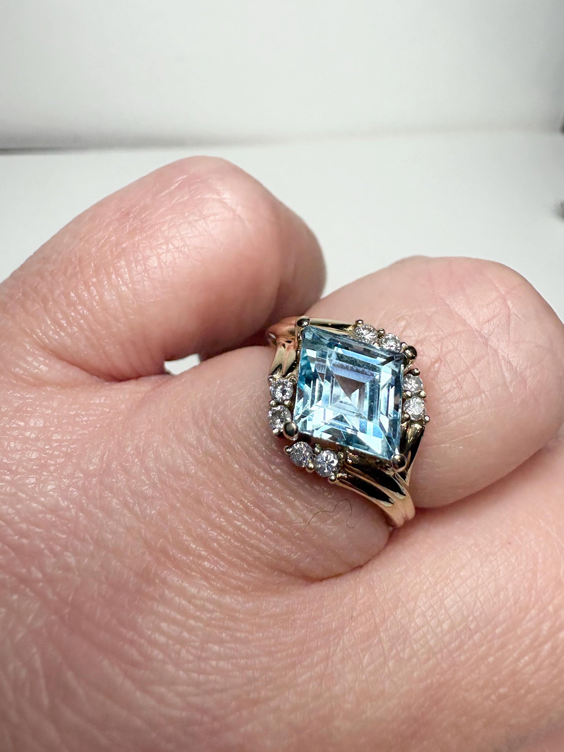 14k gold ring with a rhombus blue topaz and diamond halo.