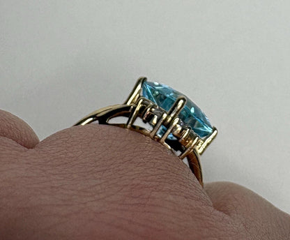14k gold ring with a large blue topaz and diamond accents.