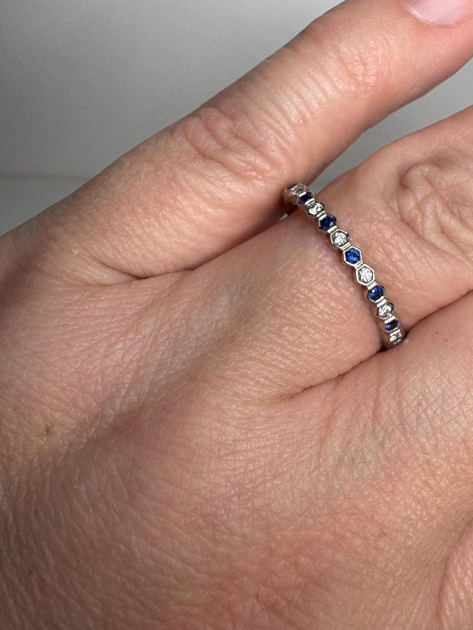A 14k white gold band ring with alternating blue sapphires and diamonds in a honeycomb hexagon pattern.