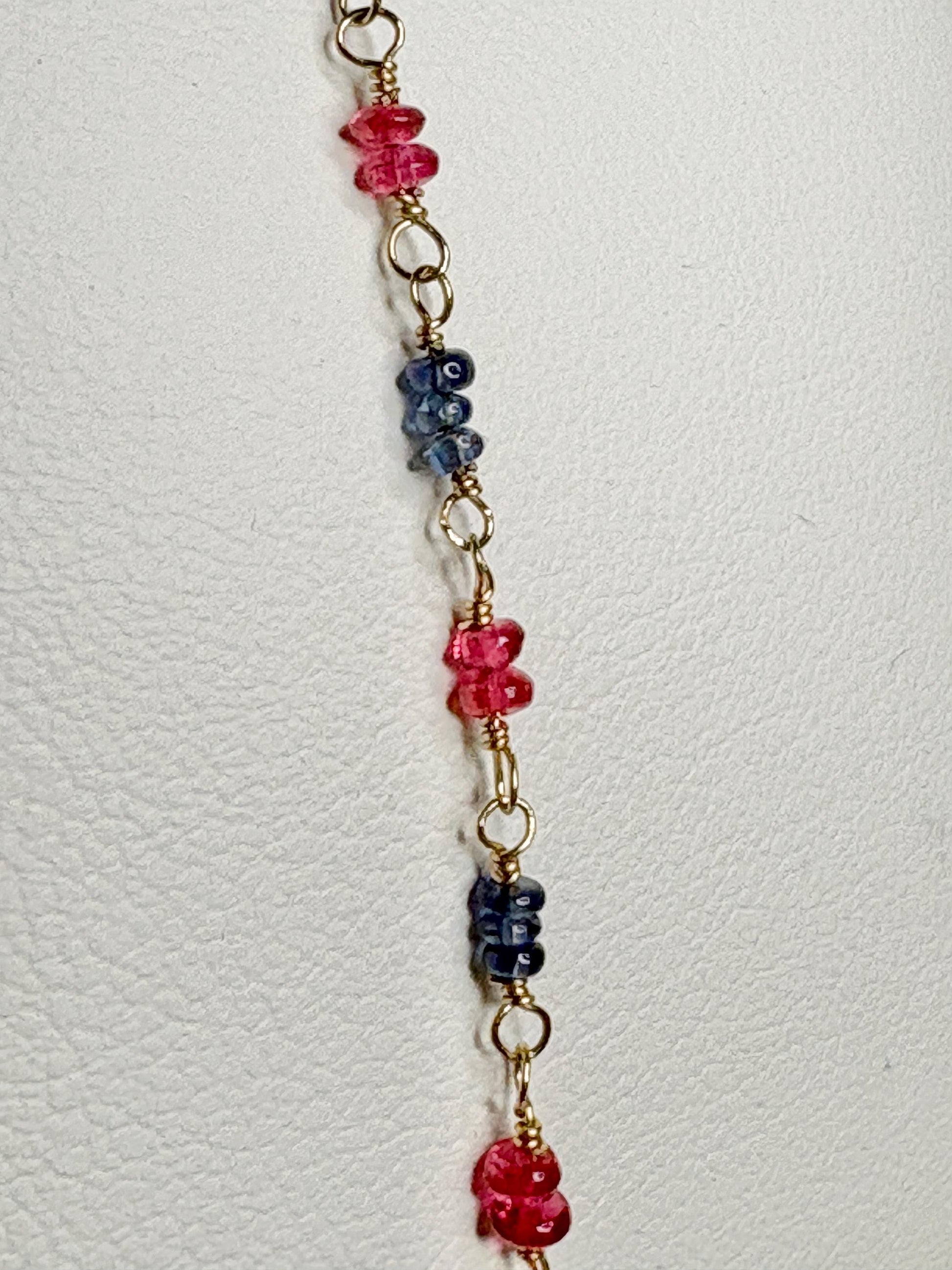 A dainty bracelet with smooth sapphire and red spinel beads on 14k gold.