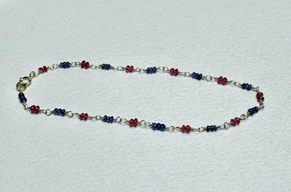 A dainty 14k gold bracelet with smooth Burmese sapphire and red spinel beads.