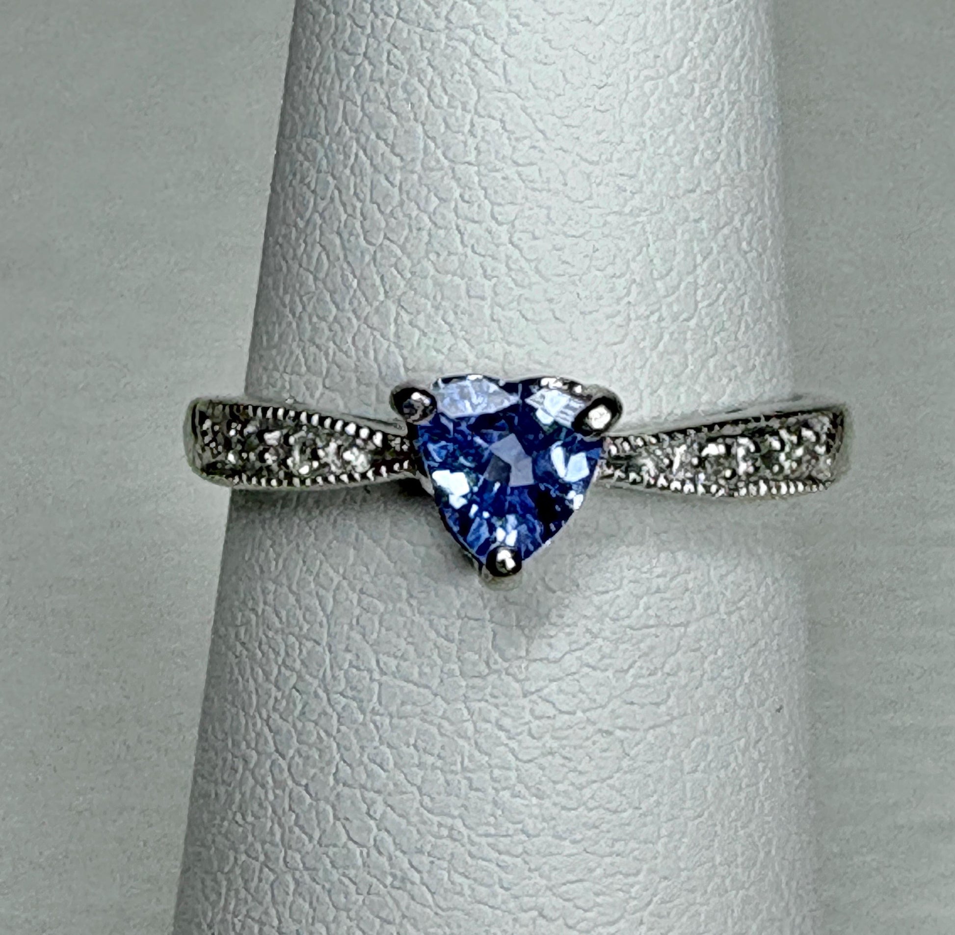Heart-shaped tanzanite ring with diamonds on a white gold band.