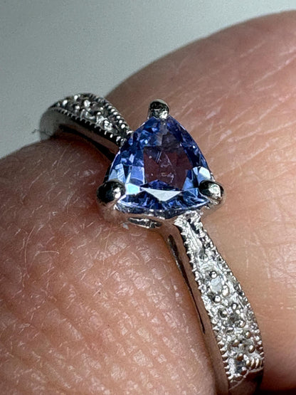 Tanzanite trillion ring with diamonds on a white gold band.