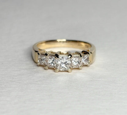 A 14k yellow gold band ring with five princess-cut diamonds.
