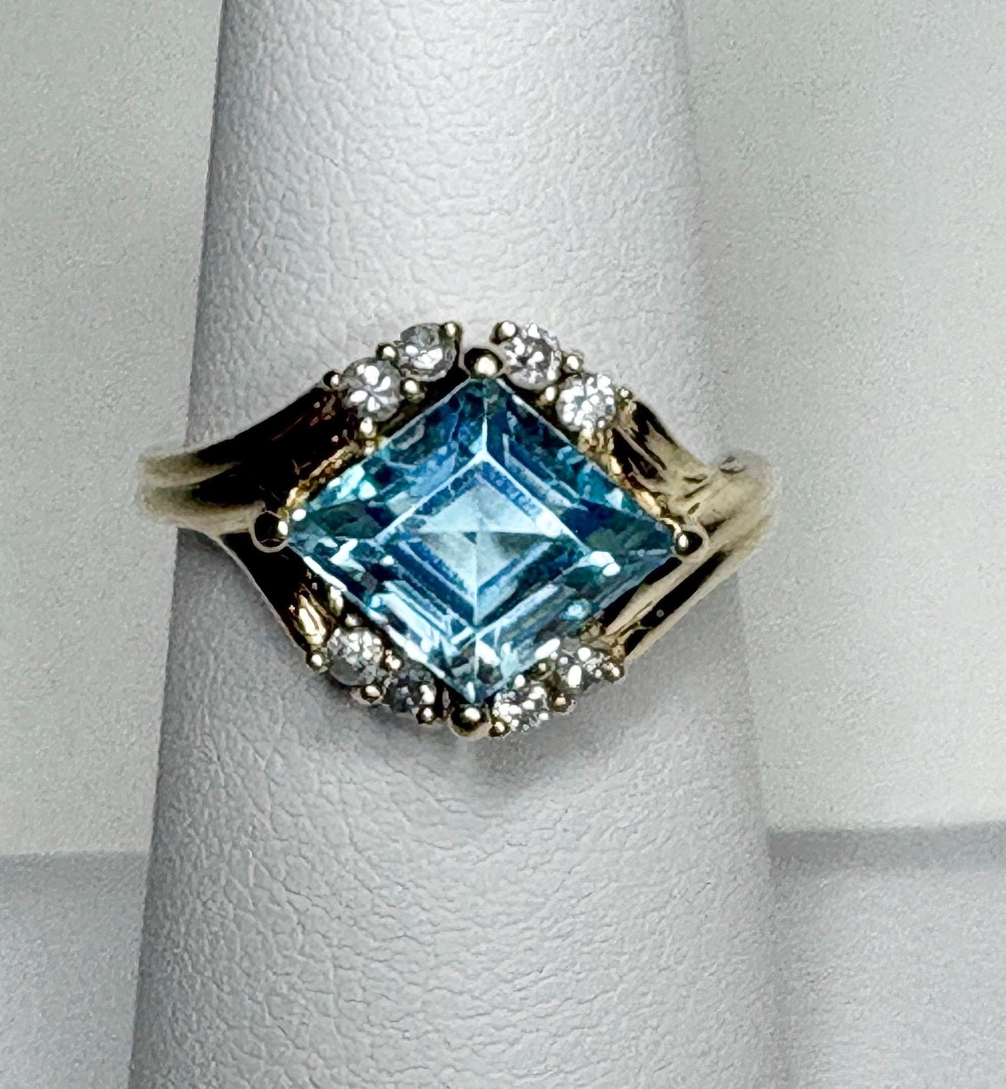 14k gold ring with a rhombus sky blue topaz and diamond accents.