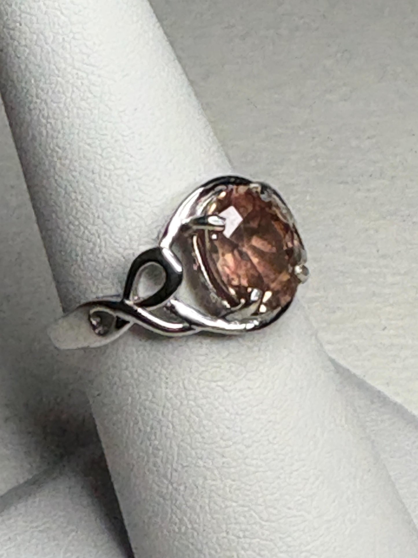 Sterling silver ring with an oval Oregon sunstone in a free-form ribbon setting.